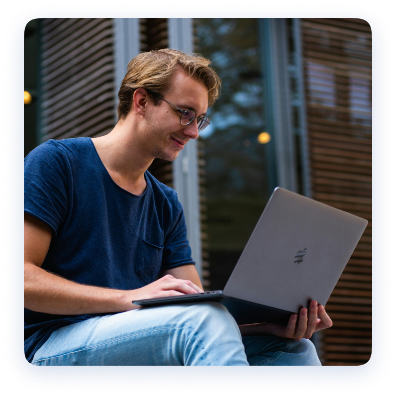 A blue t-shirt guy wearing specks using laptop